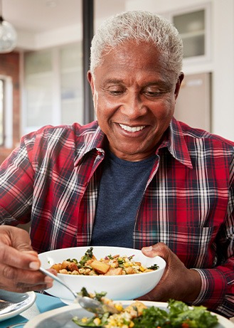 Senior man filling plate at table