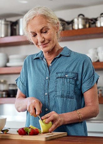 Woman smiling while preparing snack in kitchen
