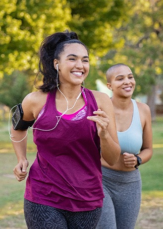 Group of women smiling while jogging in park