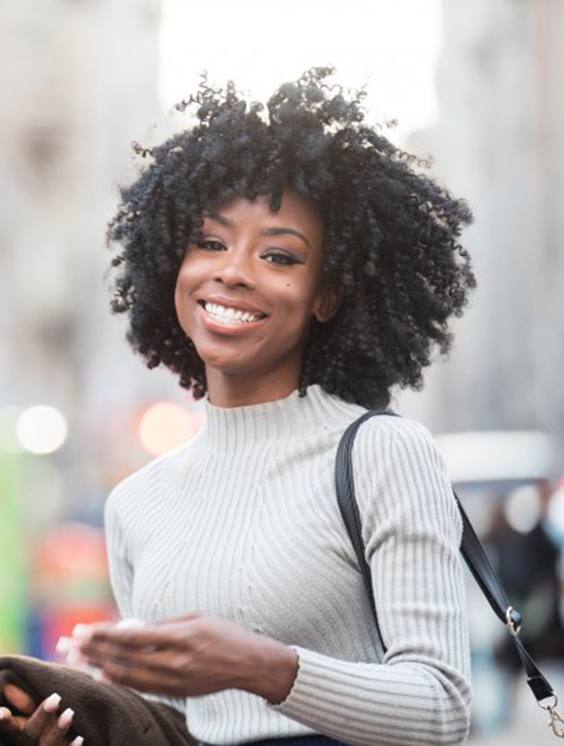 Young female smiling after a visit to her Blue Cross Blue Shield dentist in Stratford