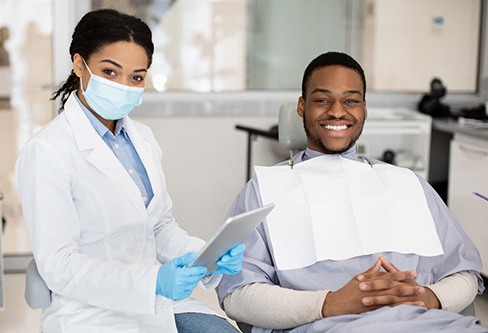 Male patient and dentist smiling
