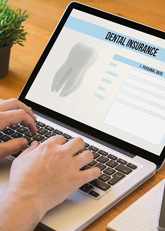 Patient filling out dental insurance form on computer