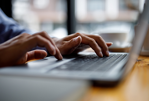 Close up of a person typing on a laptop