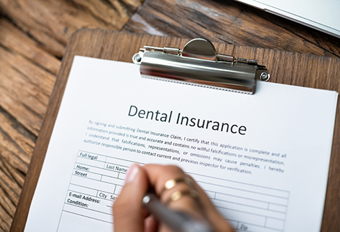 Person filling out dental insurance paperwork