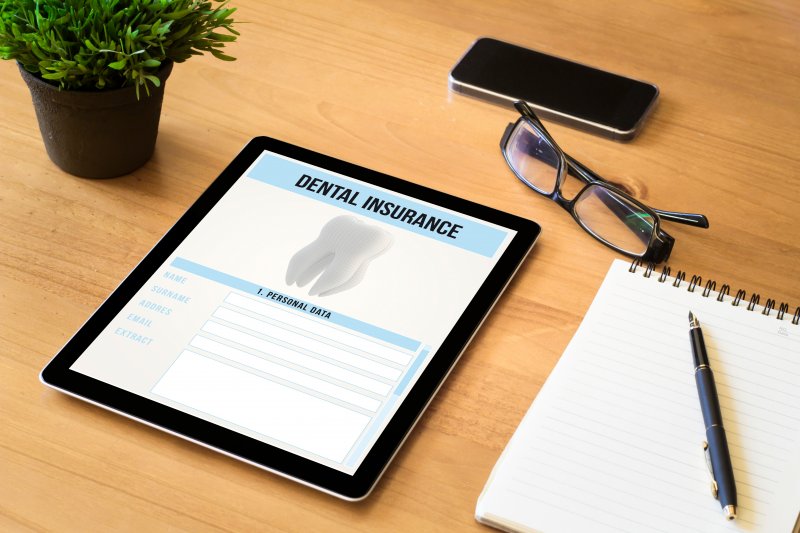 A tablet showing a dental insurance form on a desk